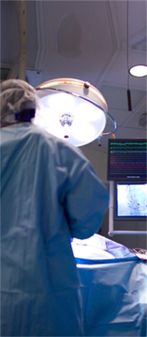 A cardiologist implants a heart defibrillator in a patient. Focus is on the fluoroscopy monitors. (14MP camera, real operation).