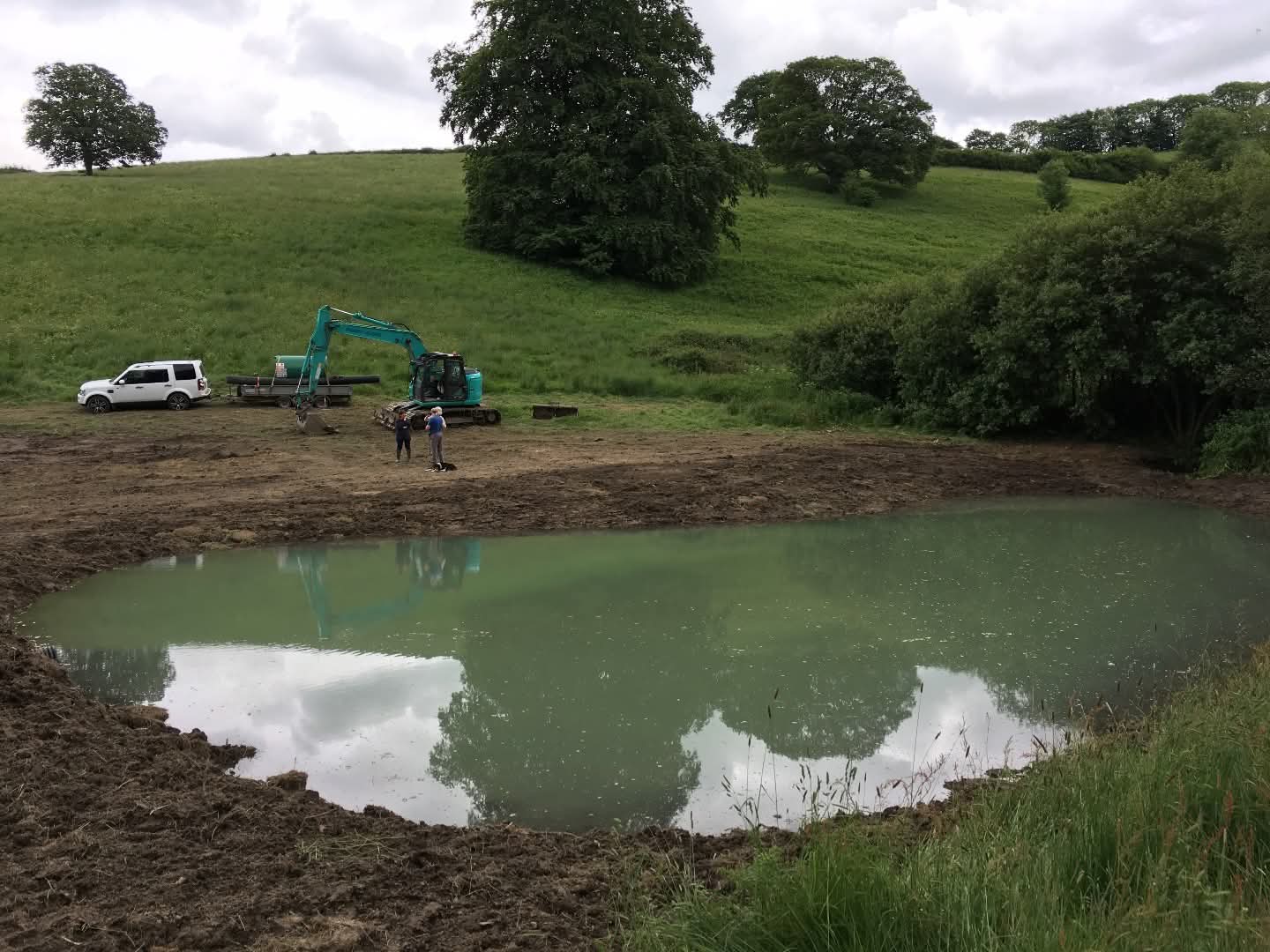 large pond surrounded by turned dirt