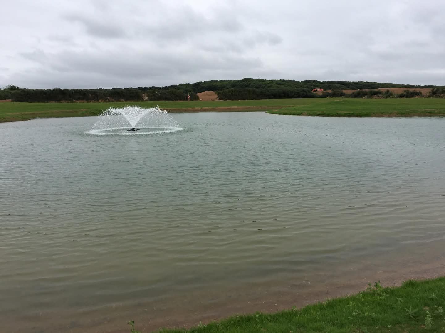 Water fountain in the middle of large pond