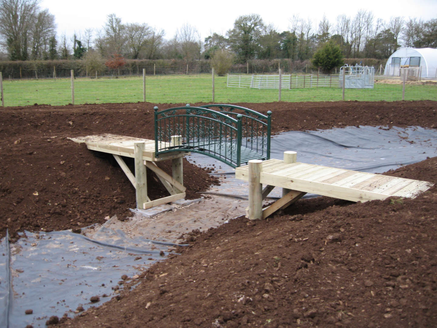 Two decks with a bridge linking over a large pond in Somerset