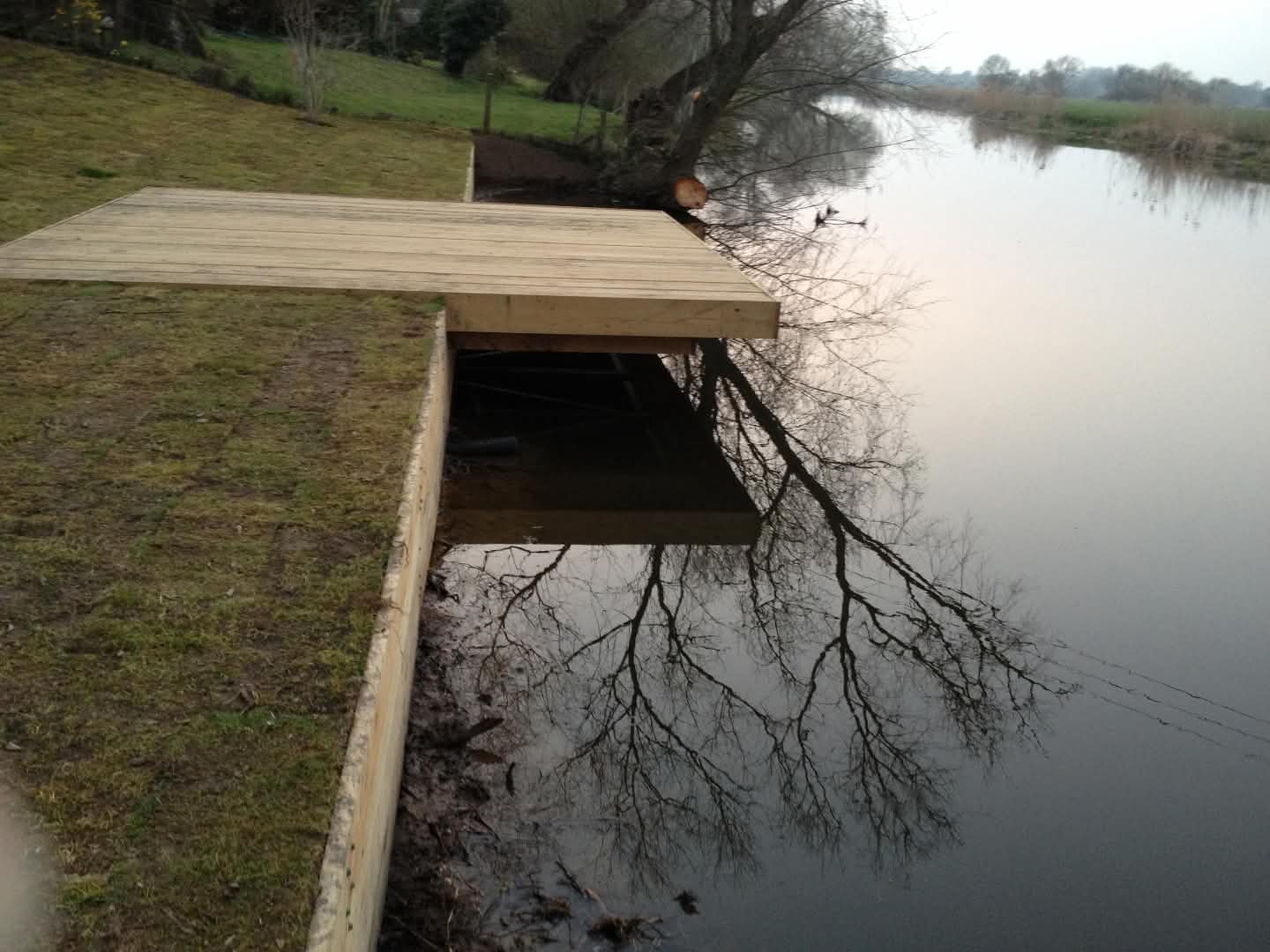 Large cantilevered deck and jetty built beside a river in Cambridgeshire.