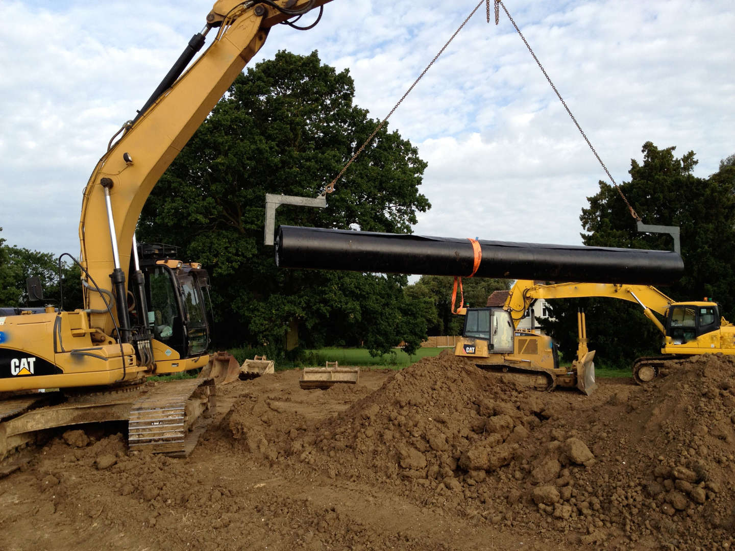 Excavator handling a roll of liner