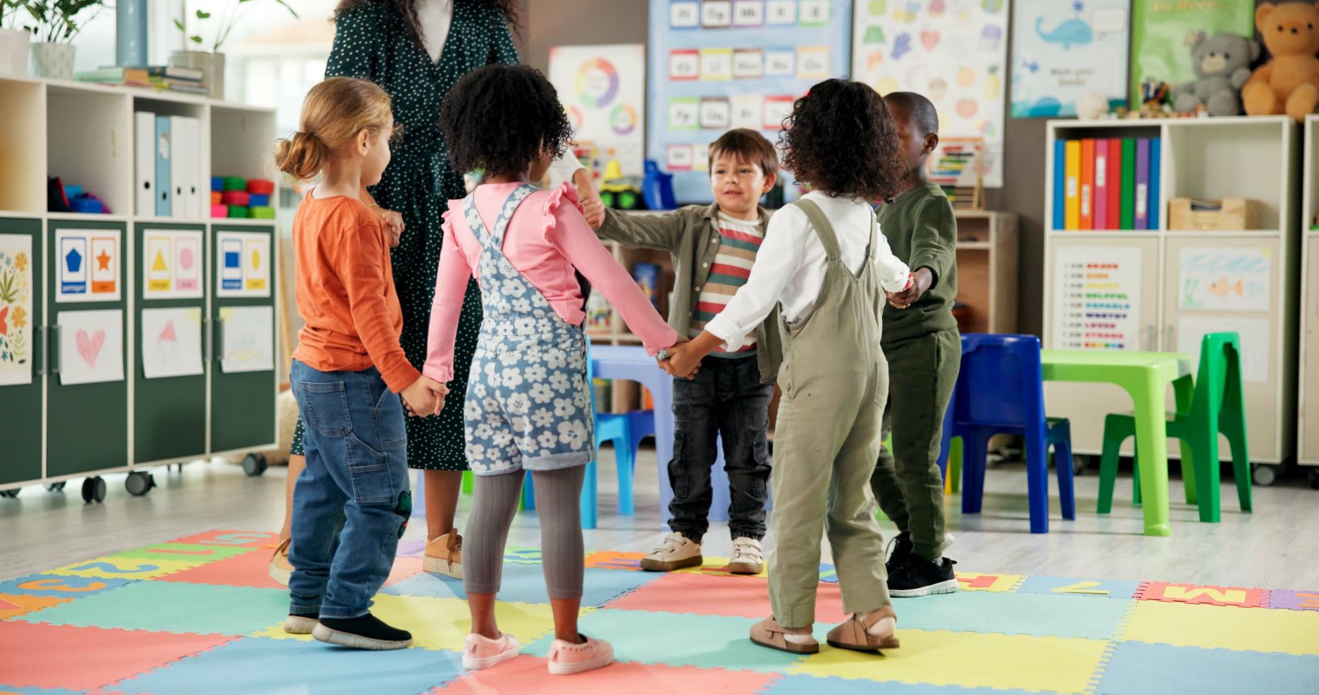 Holding hands with teacher in circle