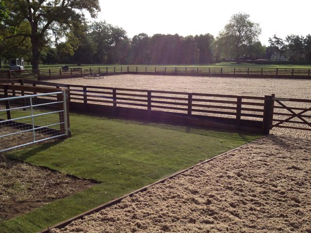 Turf laid around riding arena installation with wax surface