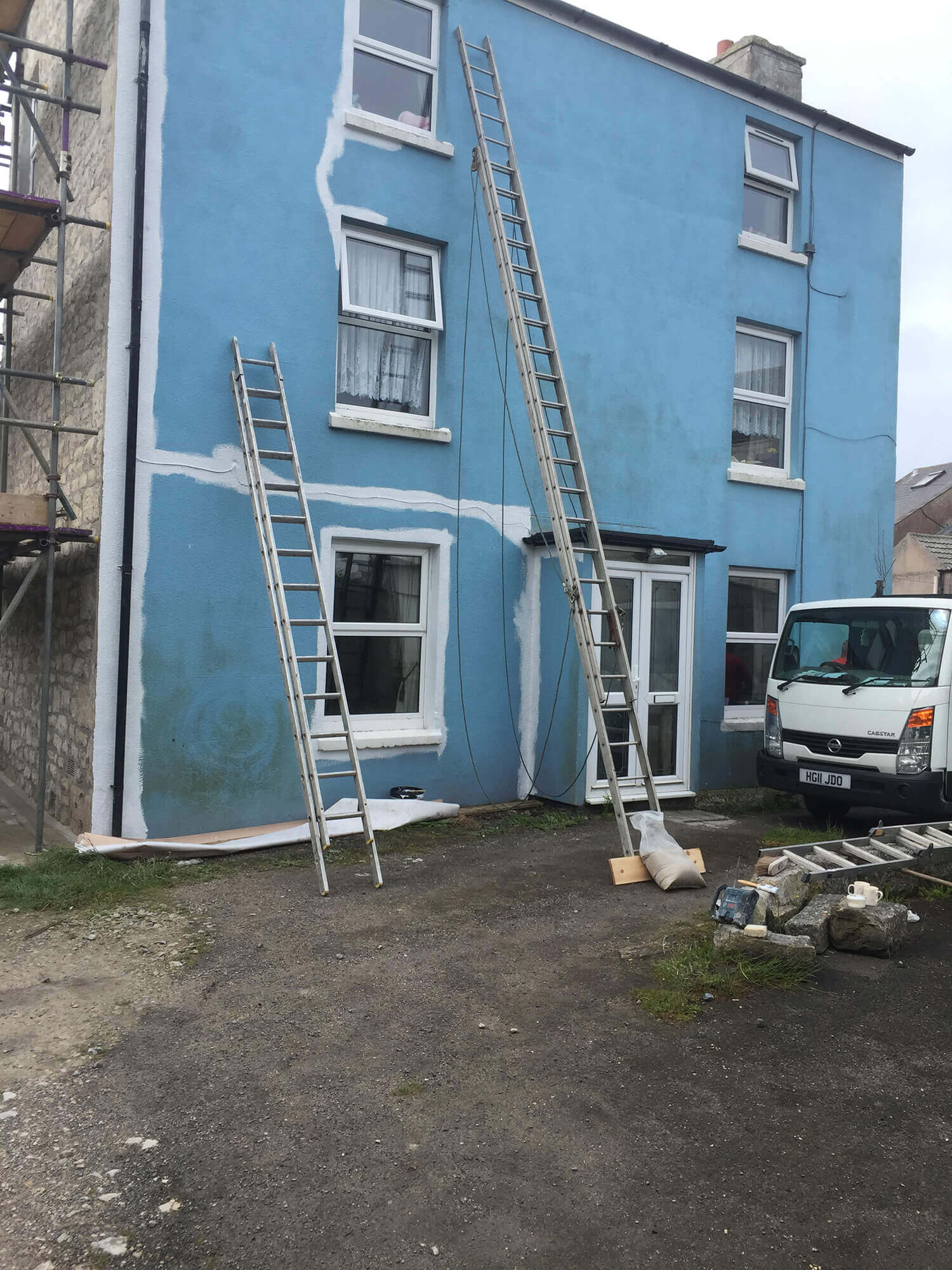 Blue house before being painted with scaffolding