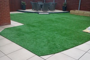Garden landscaping in Ellesmere Port, porcelain paving, artificial grass, railway sleepers for planting.