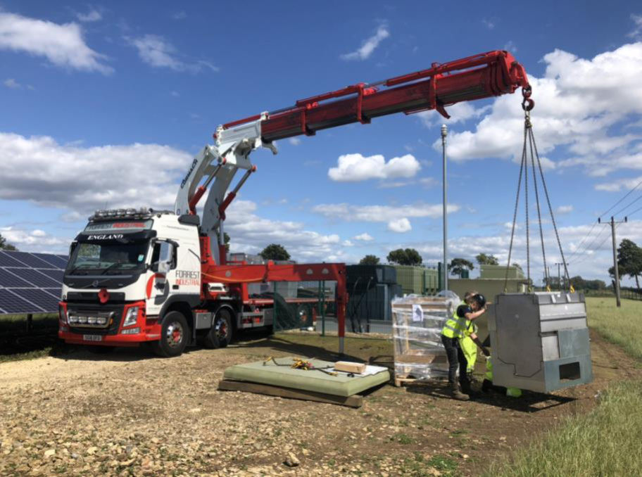 Red crane lifting metal block worker