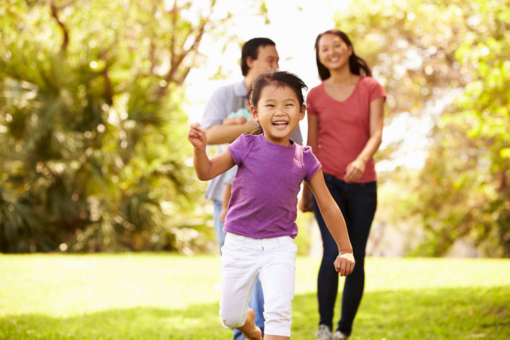 happy child being active outdoors with parents