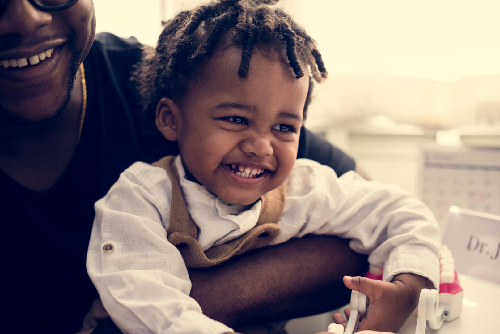 happy child being cuddled at doctor's office