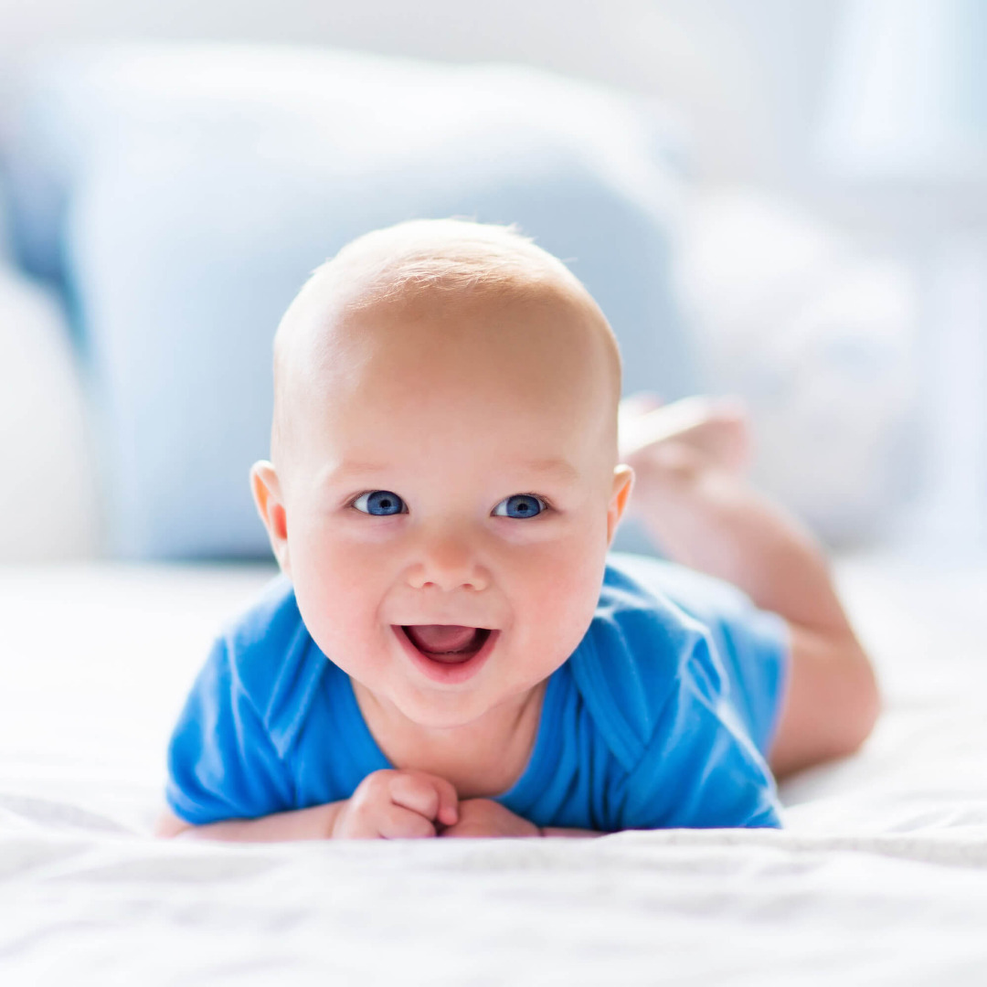 baby laughing on bed