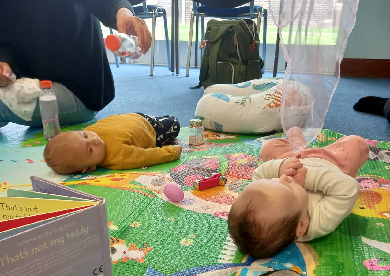 babies lying on a play mat