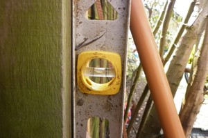How to level a fence post is called plumb levelling, using level flush to the post side & front until the bubble is centred. String line attached to neighbouring posts act as an alignment guide.