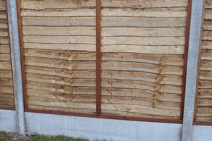 A series of thin horizontal overlapping wooden boards, nailed between 2 batons which surrounds as a frame. Three batons are evenly spaced across between the frame and nailed to the thin boards