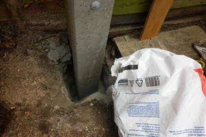 Ultimate wood fence post repair has the rot treated; coach bolts clamp the reused wooden post to a repair spur which is securely concreted 600mm in the ground. 