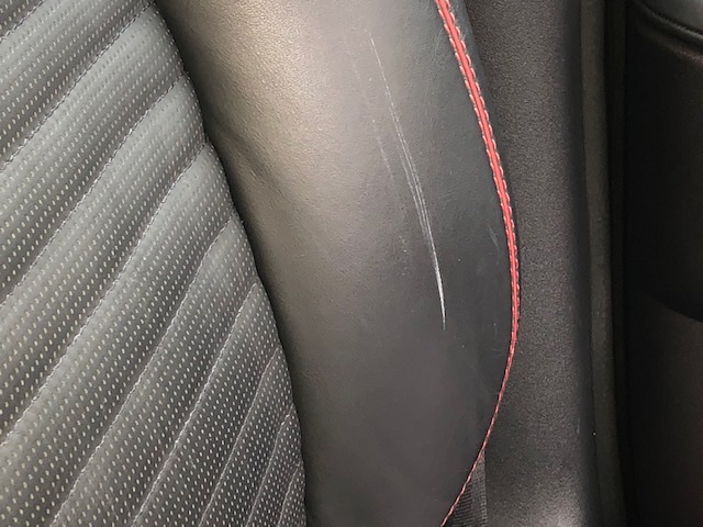 Aston Martin, scratch repair to leather driver seat, before
