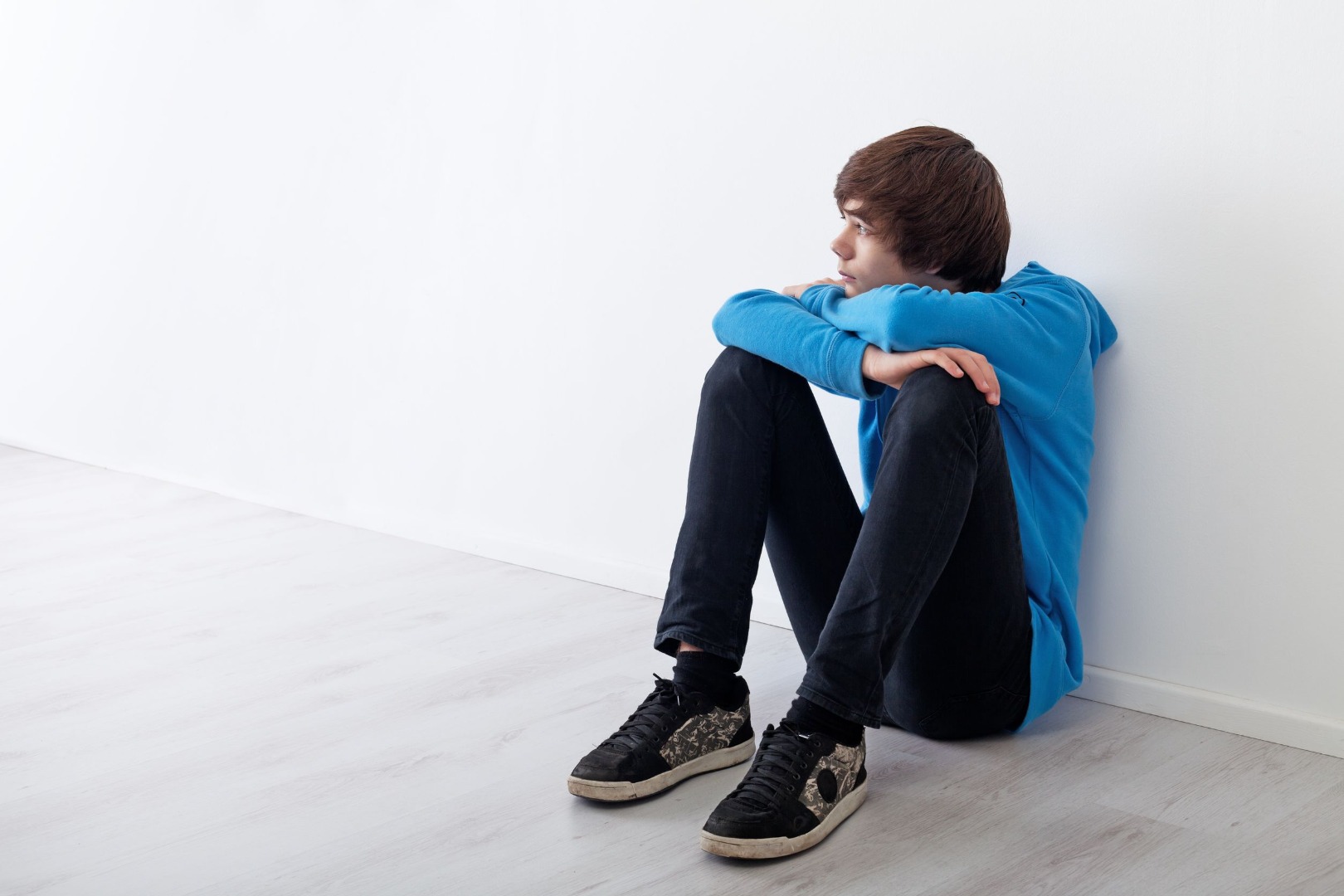 teenager sitting by the wall
