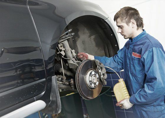 mechanic checking car brakes