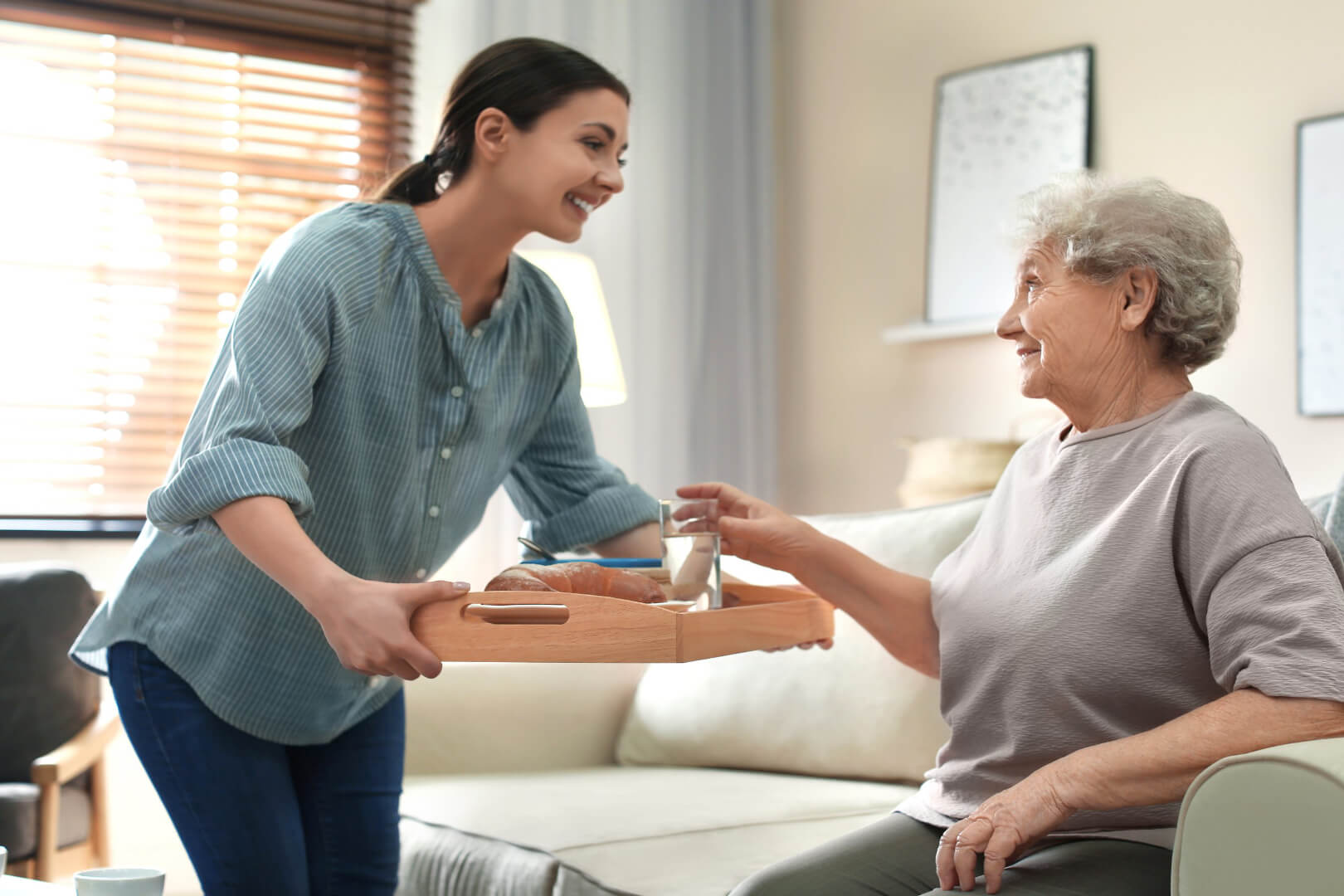 Woman giving elderly woman water