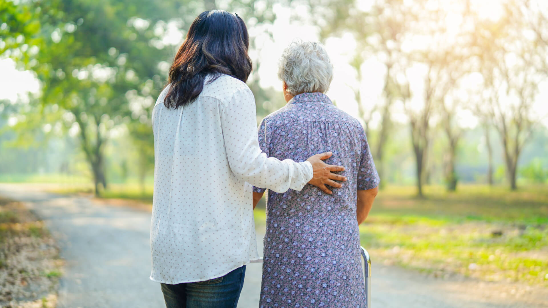 Carer helping woman walk