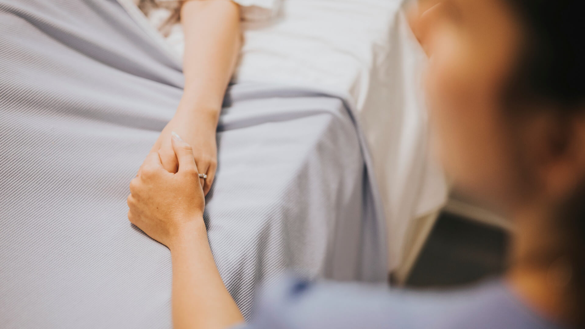 Carer holding woman's hand