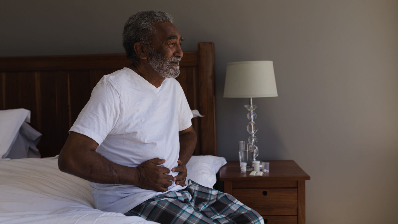 Senior man getting up from bed