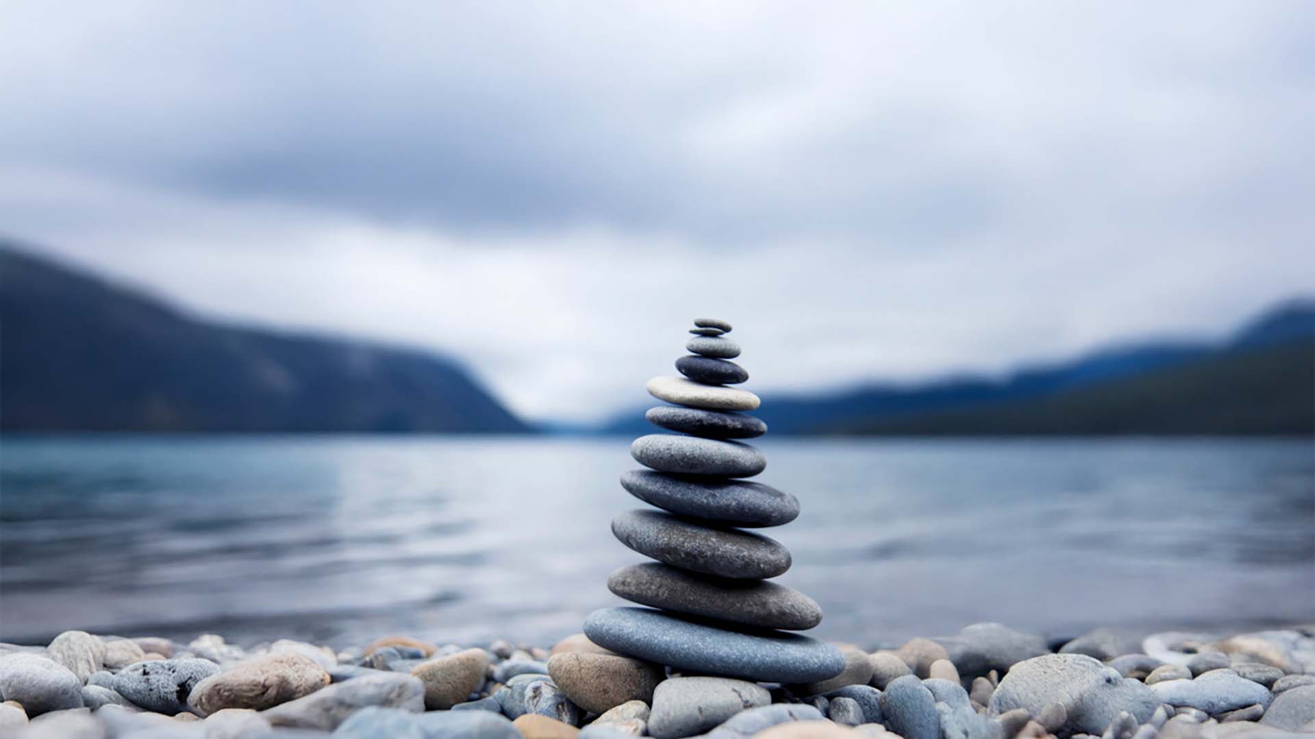 Smooth stones stacked infront of lake