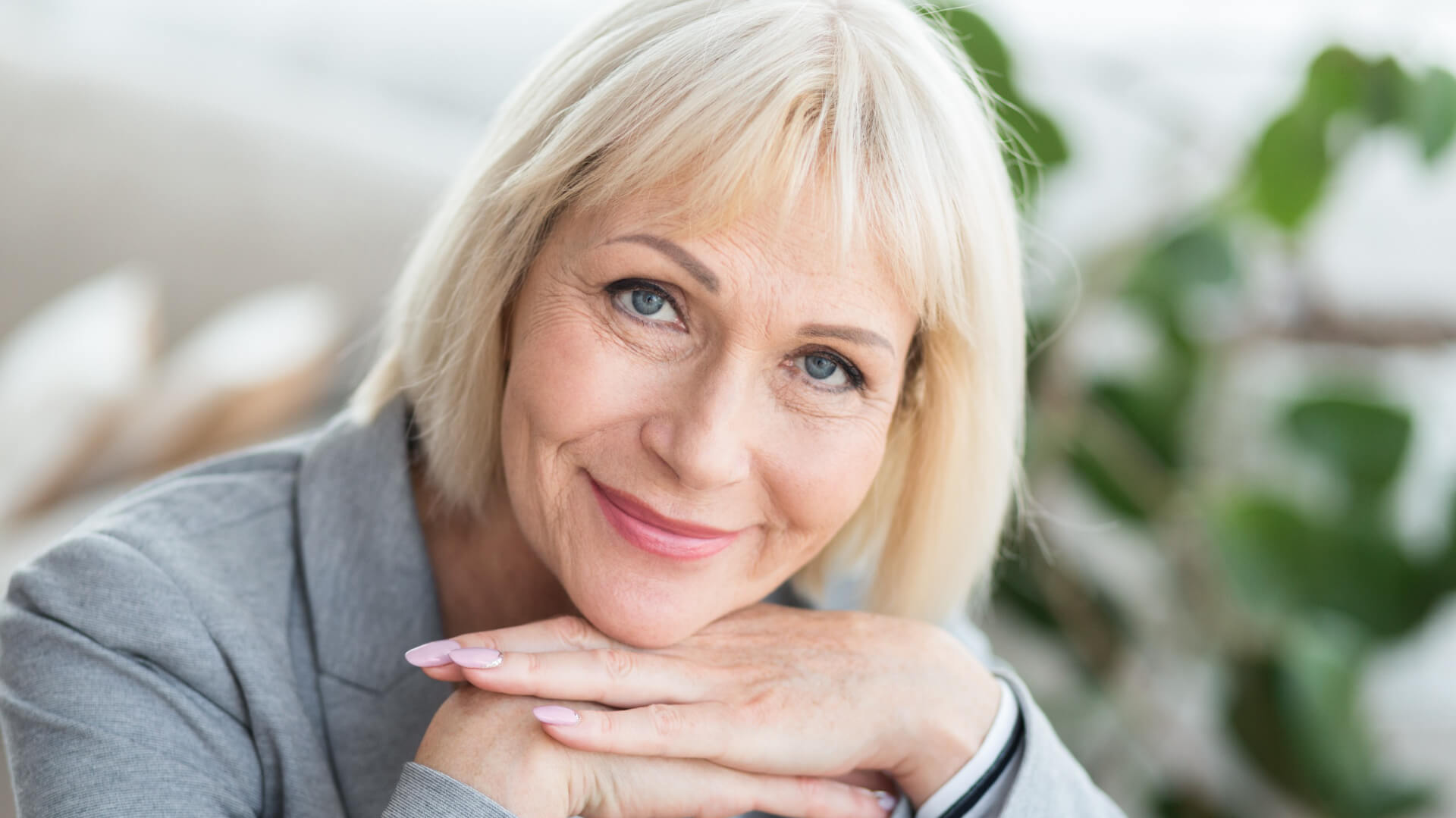 Smiling woman hands below chin