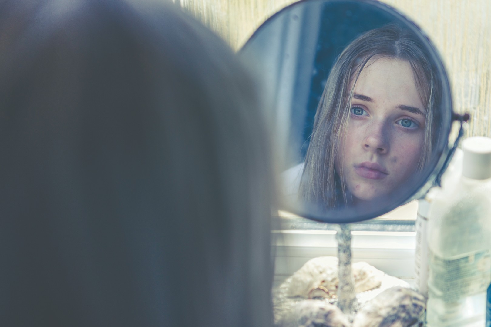 Girl watching herself in the mirror