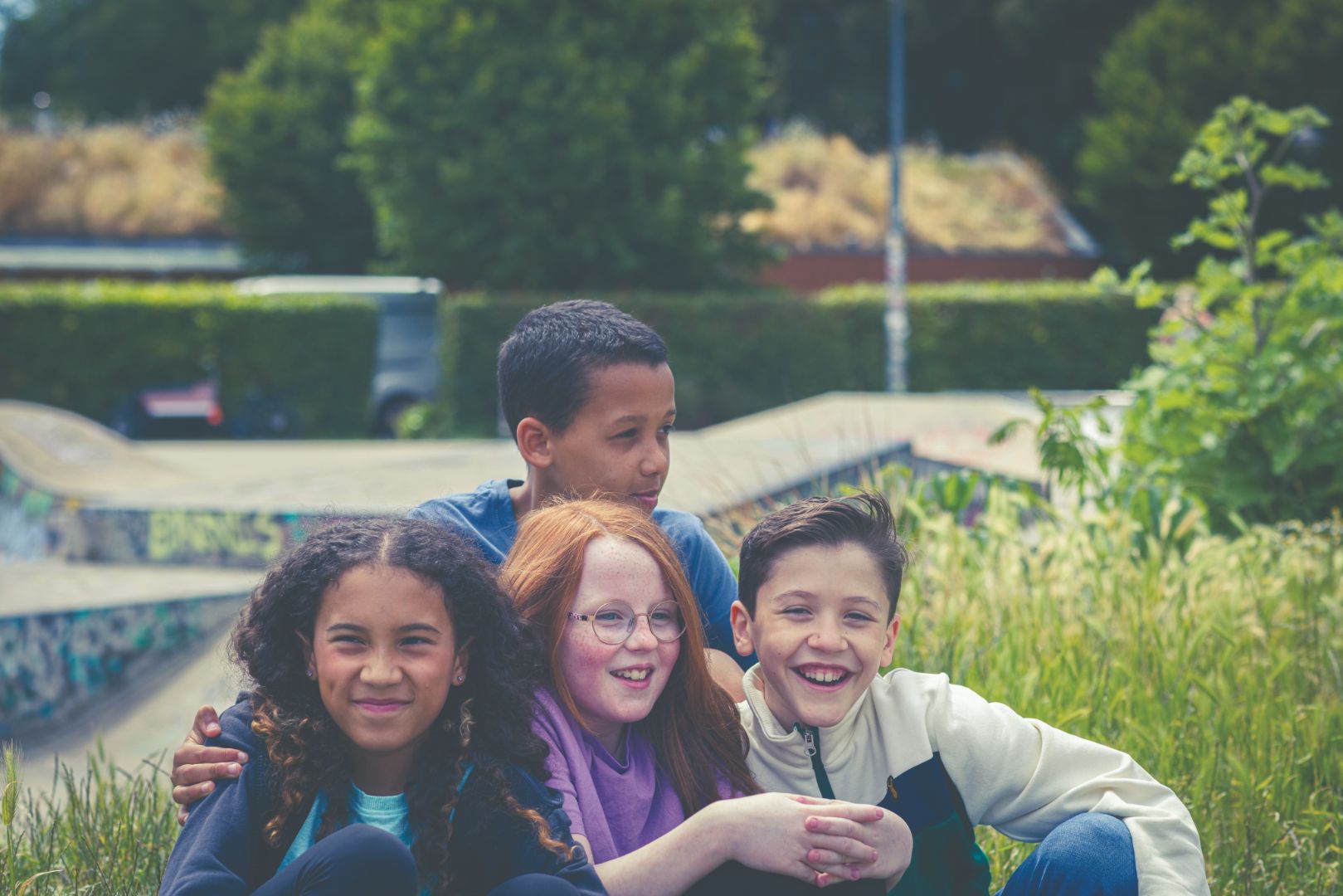 Teens boys and girls sitting on the grass