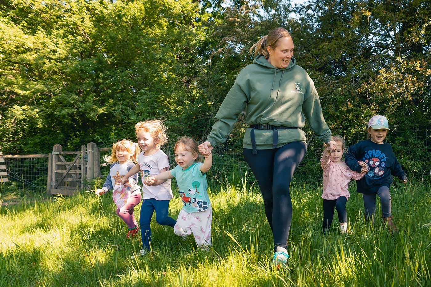Children holding hands with a woman