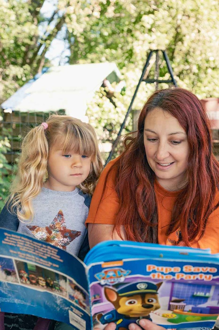 Woman reading a book to a girl