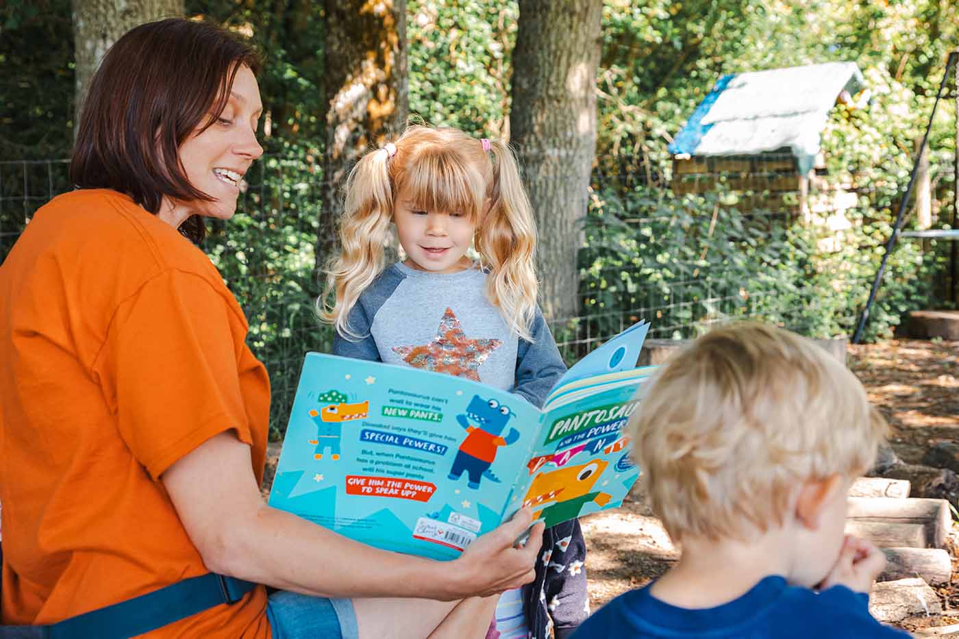 Woman reading a book to children