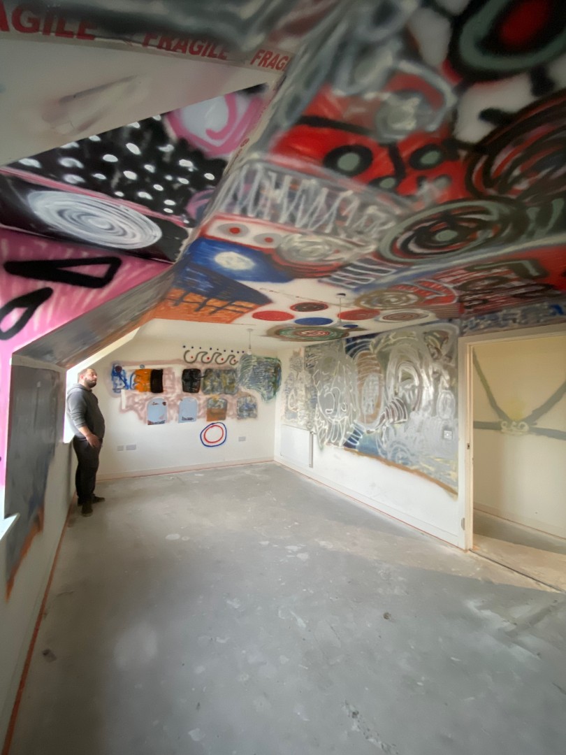Man standing in a graffitied room