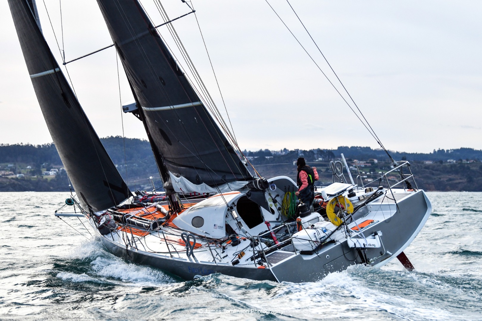 Image of Cole Brauer finishing the Global Solo Challenge, the first American woman to complete a solo race around the world non-stop, sailing First Light (ex Dragon), her Owen Clarke Design Class 40.