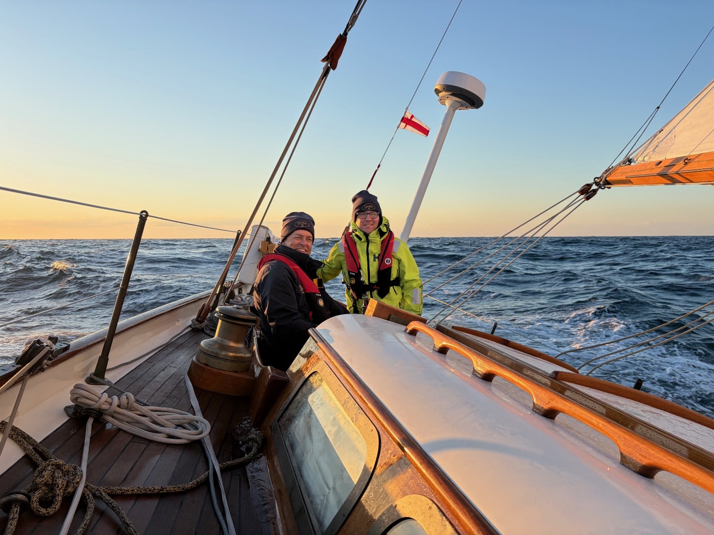 Owen Clarke designer Merfyn Owen takes sunset photograph of his other watch members aboard the classic yacht Gesture during the 2026 Newport Bermuda Race