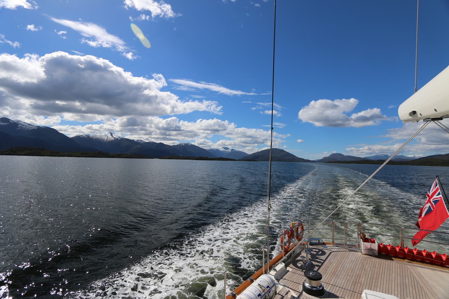 A photograph of a superyacht sailing through the canals being piloted by Ashley Perrin of Antarctic Ice Pilot. AIP run cruising yacht adventure and shoreside expeditions to Patagonia and Chile.