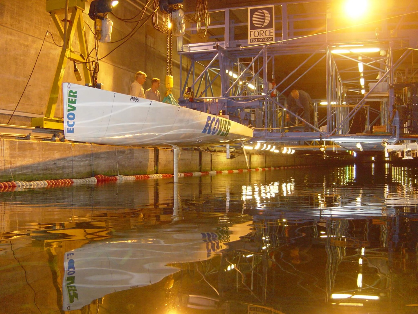 This is a photograph taken during the 1/3rd scale towing tank model testing undertaken on the Owen Clarke / Clay Oliver designed IMOCA 60 Ecover 3 in 2005. During these tests an interceptor trim control system, such had been previously fitted to Russian Navy fast attack craft was investigated and subsequently fitted to sisterships Ecover 3 and Aviva. When Ecover 3 took part in the 2007 TJV, this was the first time an interceptor system had been used by a sailing yacht. The system was subsequently banned by the IMOCA class technical committee after both yachts raced with it in the 2008 Vendee Globe.