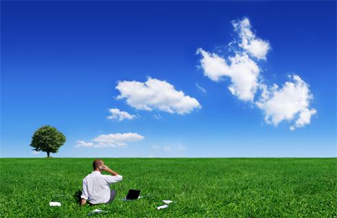 Feel free in business. Businessman on green filed and the blue sky in background. The picture was made from three big photos and downsized for better quality.